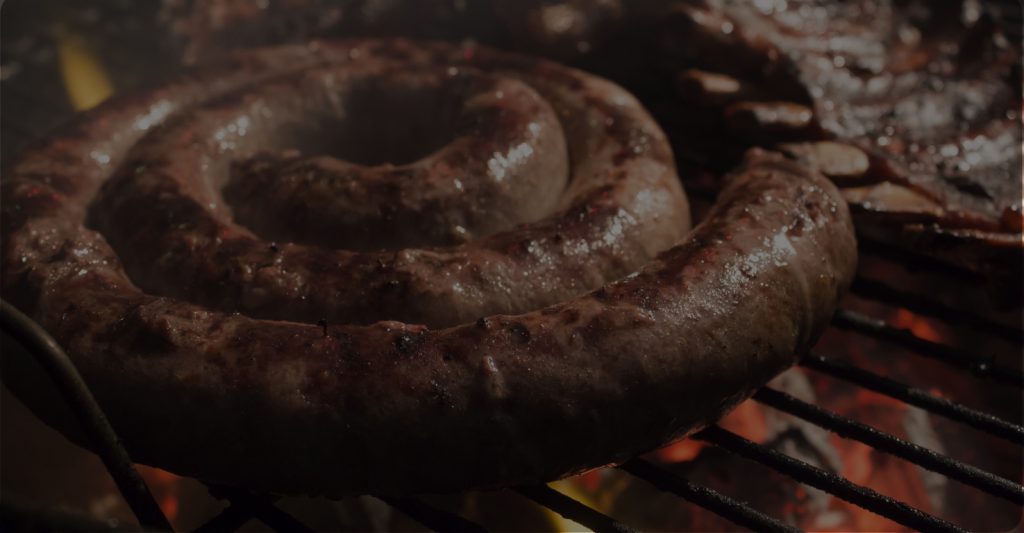 Closeup of Boerewors sausage cooking over hot coals